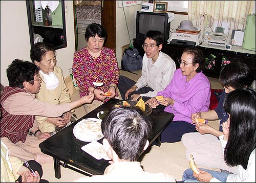 단촐한 먹거리 앞에 가장 귀한 얼굴들이 마주 앉았다. 한 할머니가 관부재판 지원단 일행에게 과일을 건네고 있다. 다른 한 할머니는 한사코 카메라를 피한다. 아직도 자신의 젊은시절이 노출되는 것을 꺼리기 때문이다. 